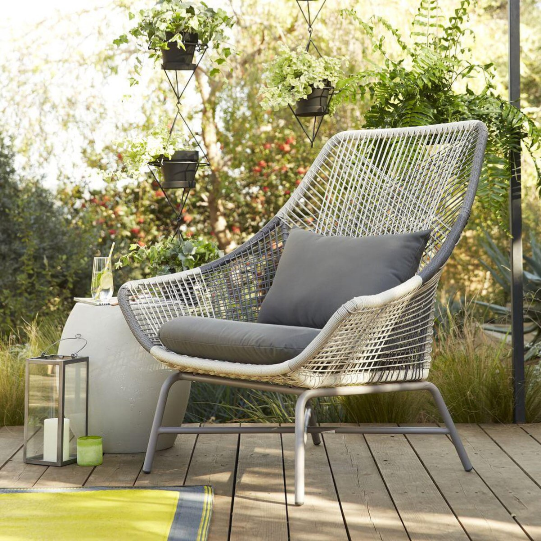 Contemporary rattan lounge set; image shows lounge chair in a garden setting