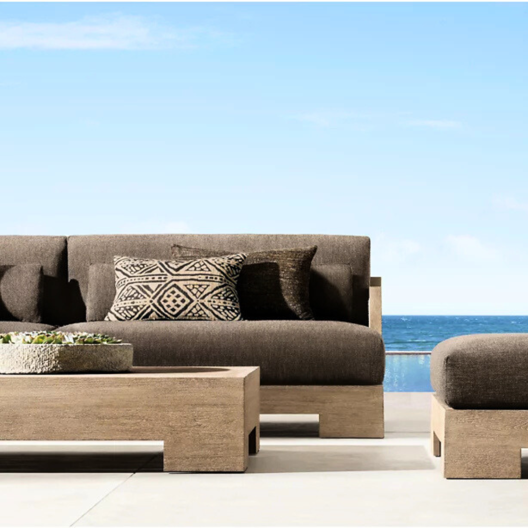Teak garden table with modern rectangular shape, paired with an outdoor settee set with a luxury costal outdoor background.