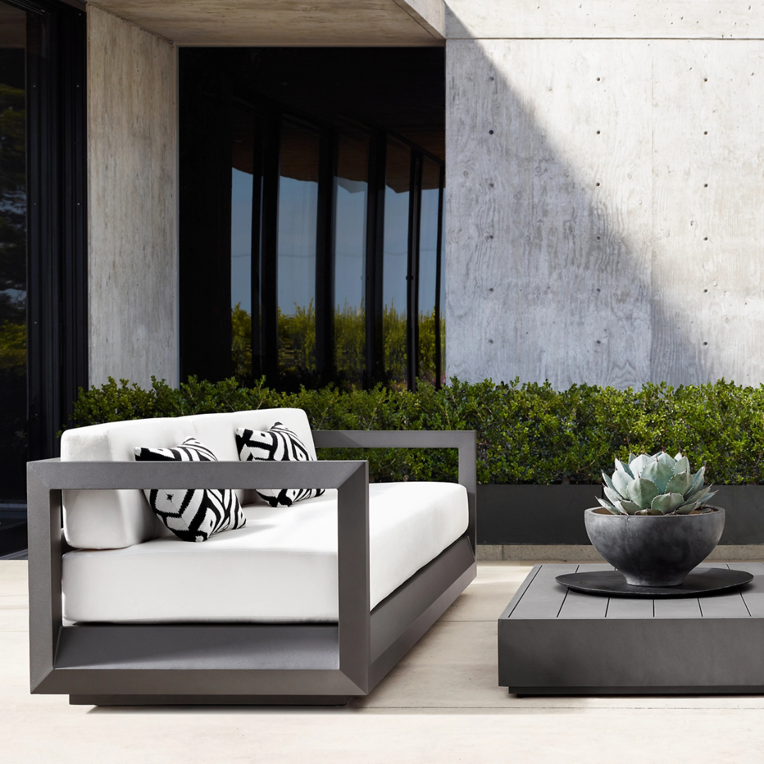Luxury aluminium fire pit garden furniture set with cushions, black frame, and white cushions; the image shows the sofa accompanied by the coffee table.