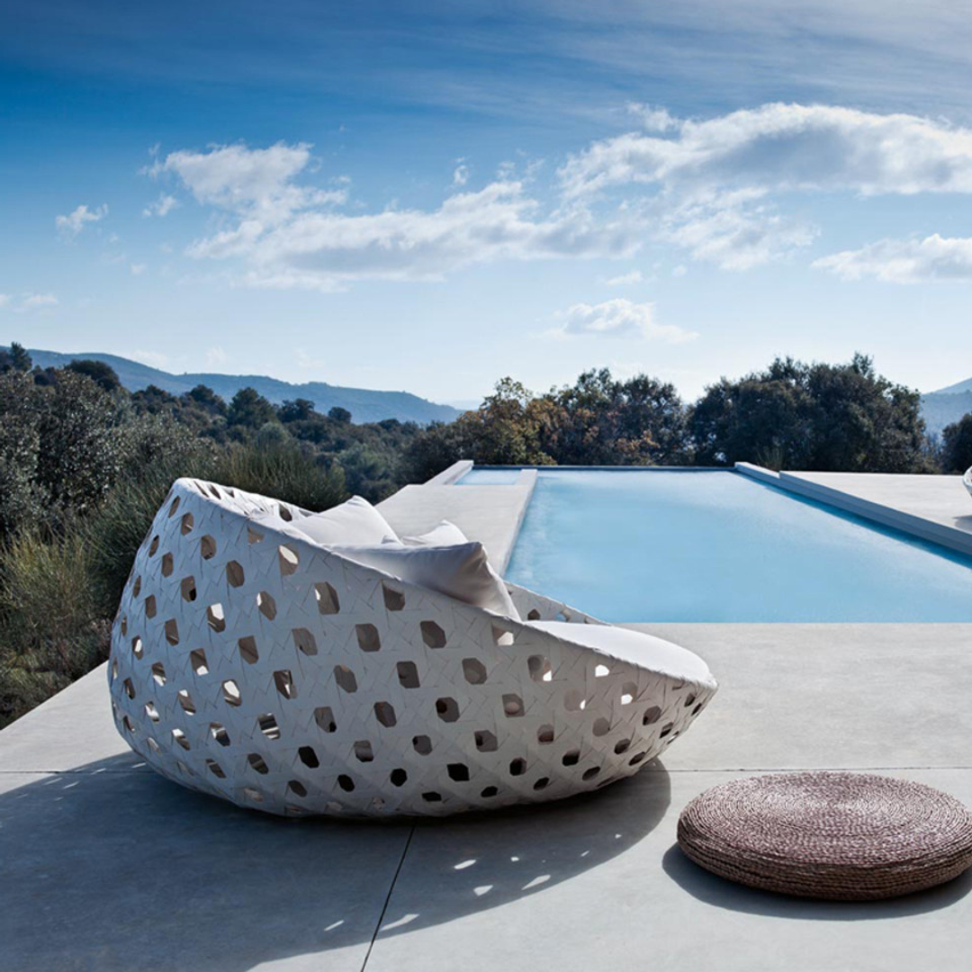 White Contemporary Woven Outdoor Round Daybed with plush cushions, in a scenic background