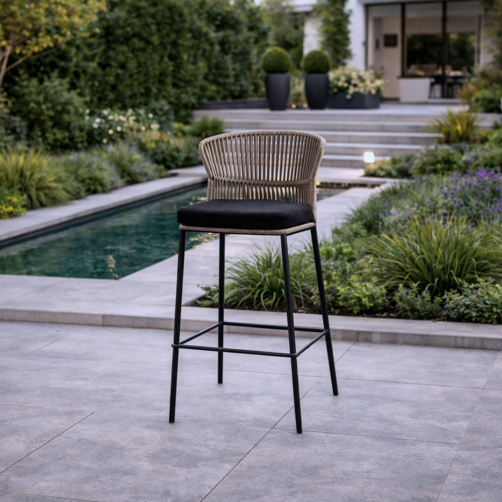 Bar stool with woven backrest and black seat on a patio near a pool