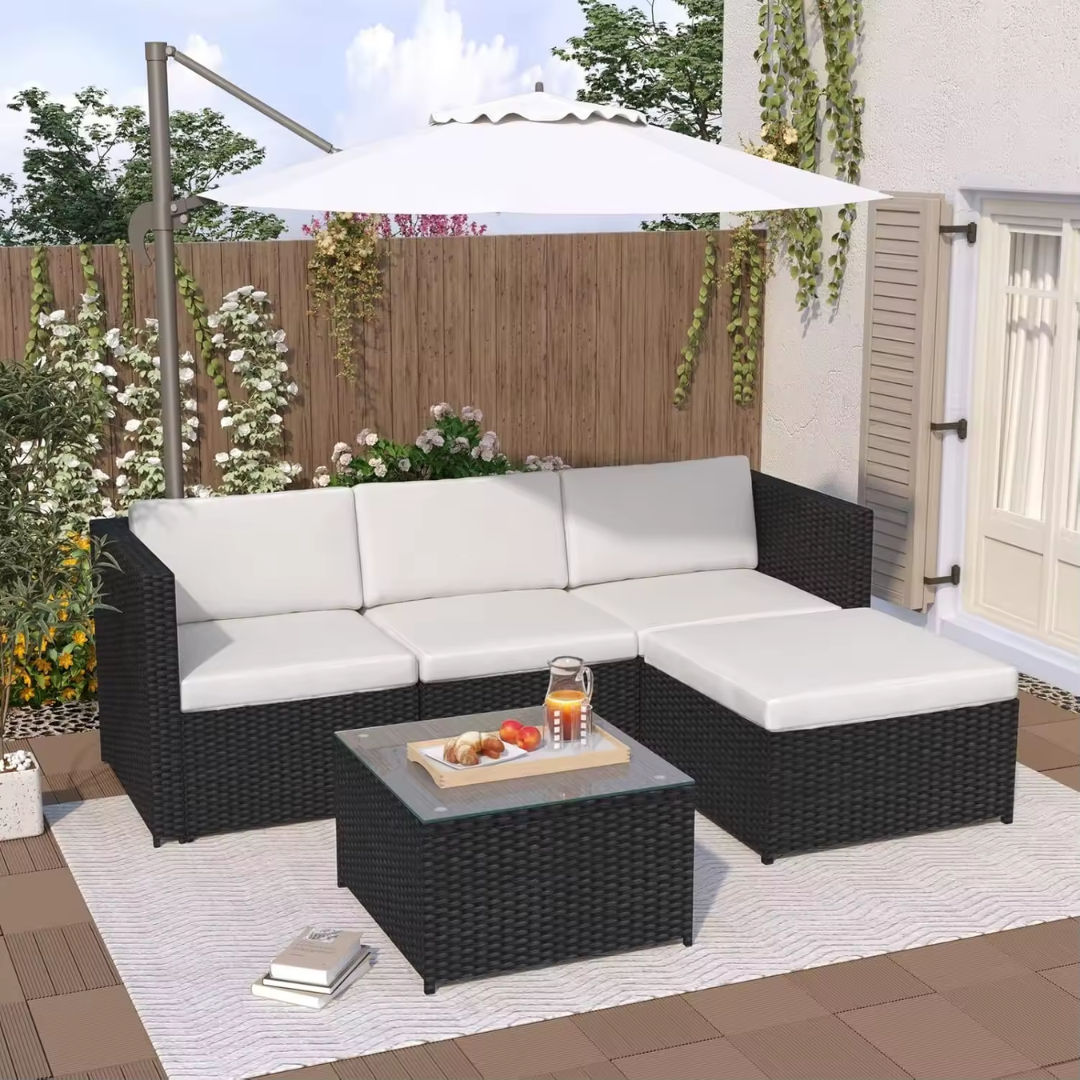 Black rattan corner sofa with cushions in a garden