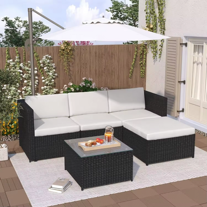 Black rattan corner sofa with cushions in a garden