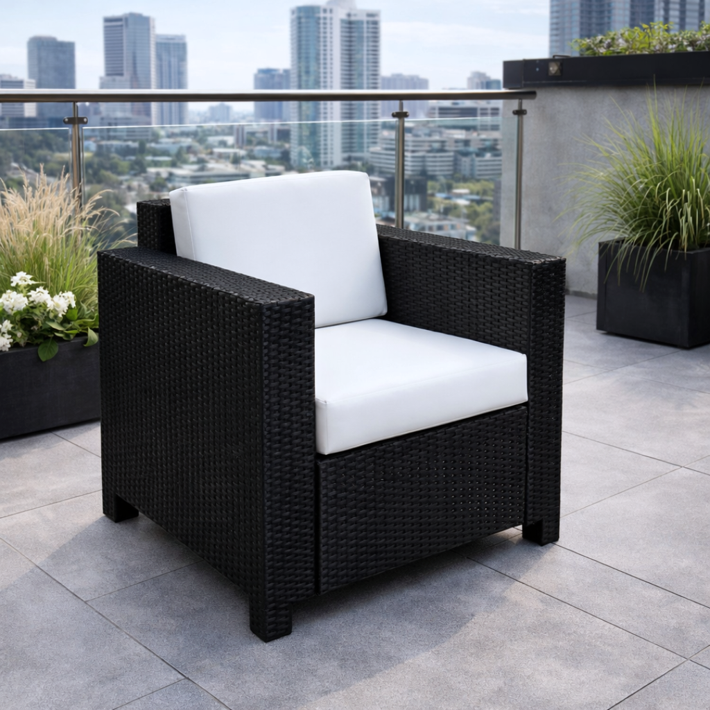 Black wicker chair with white cushion on a rooftop terrace with cityscape view
