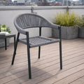 Gray outdoor chair on a wooden deck with plants and cityscape in the background