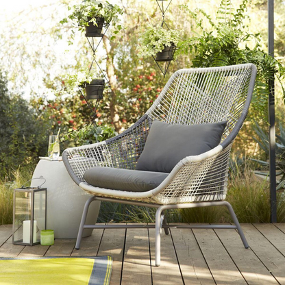 Contemporary rattan lounge set; image shows lounge chair in a garden setting 