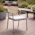 Outdoor chair with wicker backrest and white cushion on a wooden deck