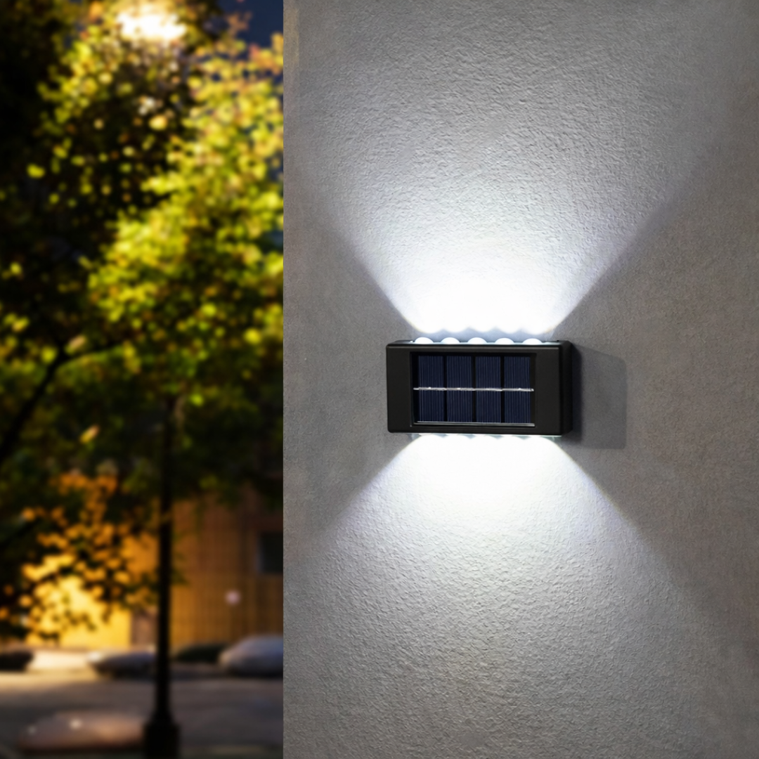 Solar-powered outdoor wall light fixture on a building exterior at night.