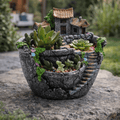 Decorative pot with miniature house and succulents on a stone surface
