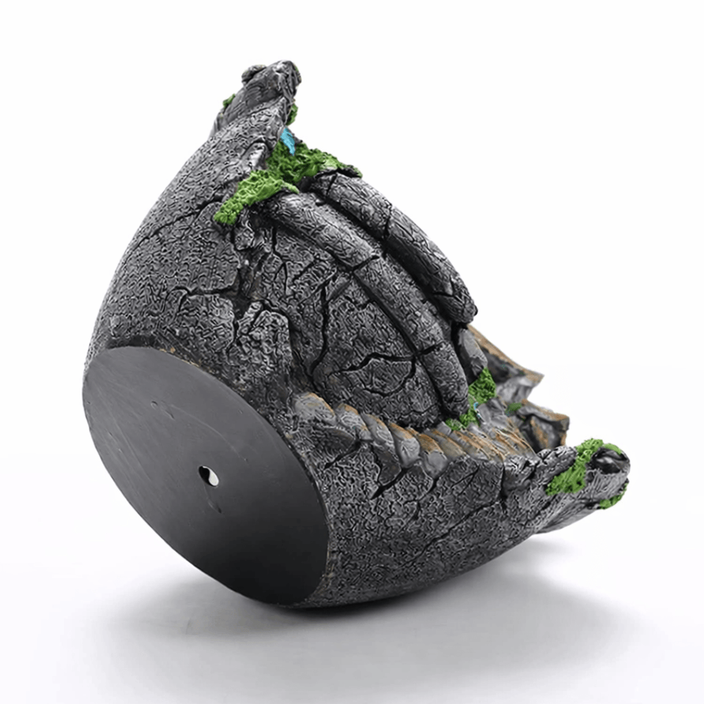 Decorative stone birdhouse with moss on a white background