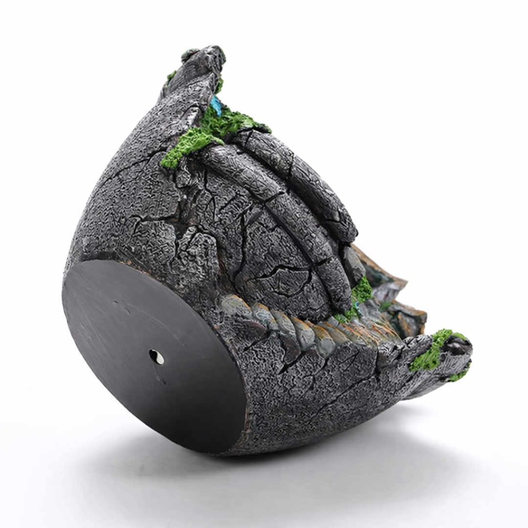 Decorative stone birdhouse with moss on a white background