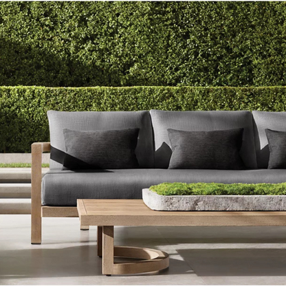 Low outdoor coffee table with natural wood finish, set up in outdoor luxury background.