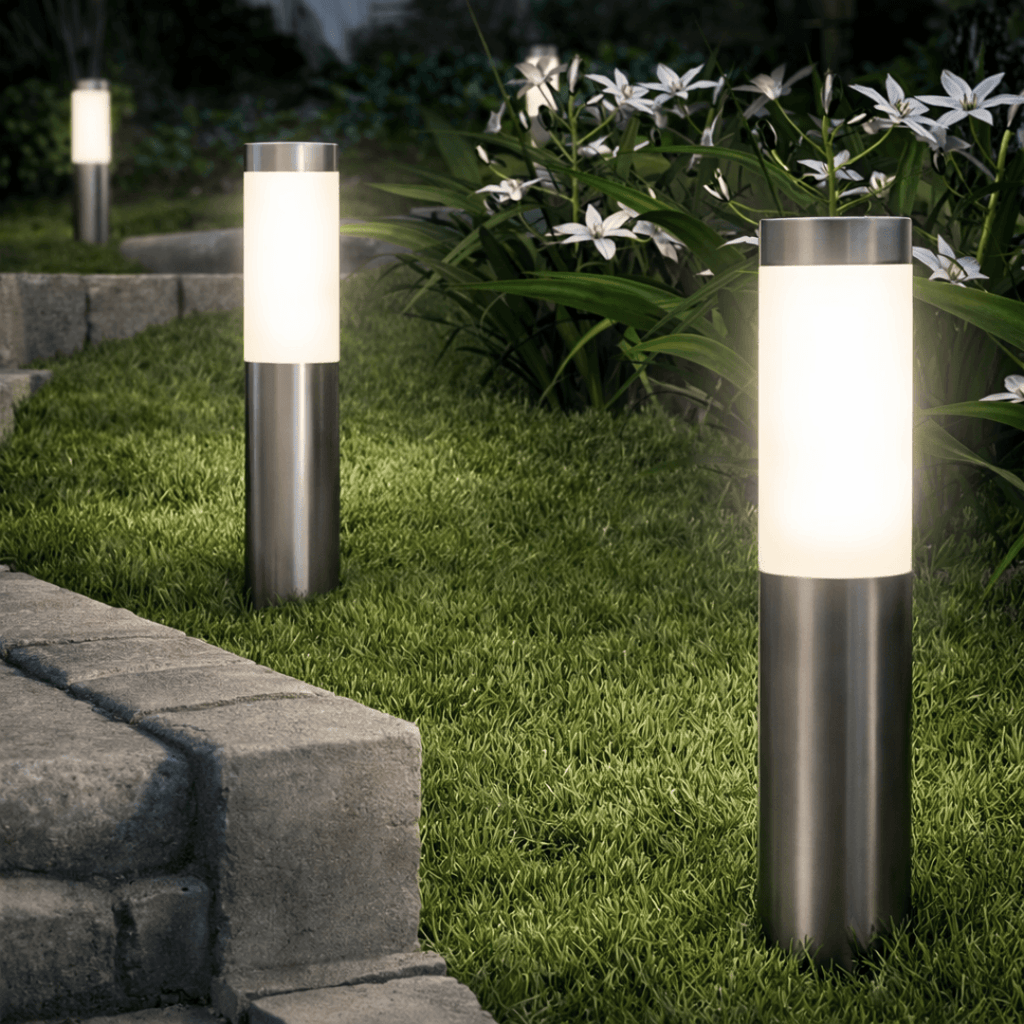 Two garden lights on grass with plants in the background