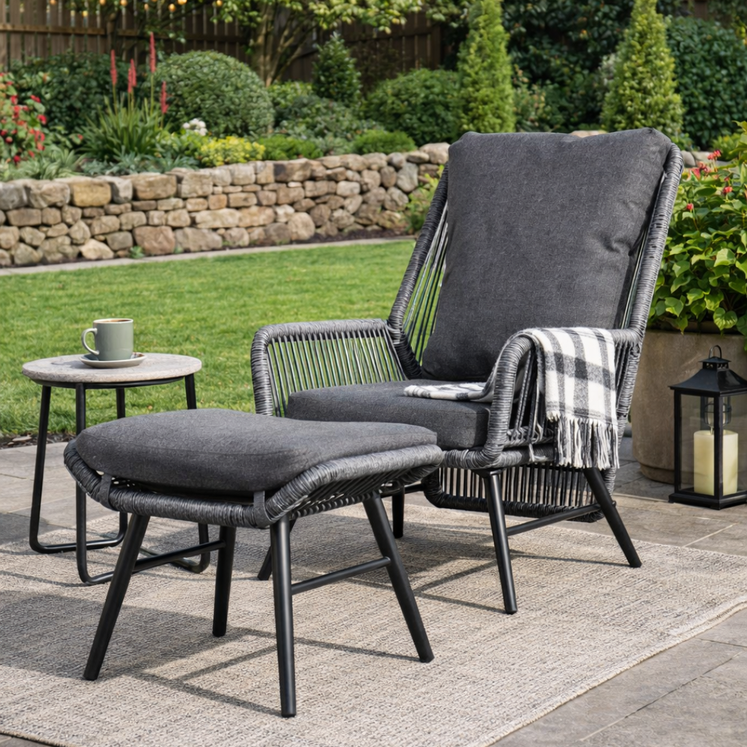 Outdoor patio set with lounge chair and ottoman on a patio area with garden background.