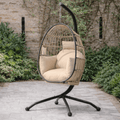Modern beige hanging egg chair with metal frame, set in a modern outdoor patio.