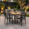 Outdoor patio set with a wooden table and black chairs on a stone patio.