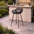 black wicker outdoor bar stool set in a modern garden with a bar.