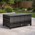 Outdoor patio table with wicker design on a patio area with garden background