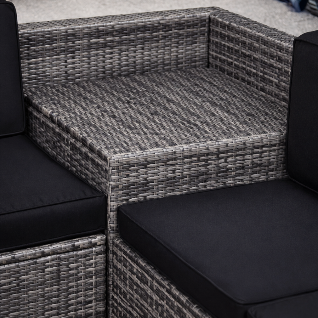 Gray wicker outdoor furniture set with black cushions on a neutral background