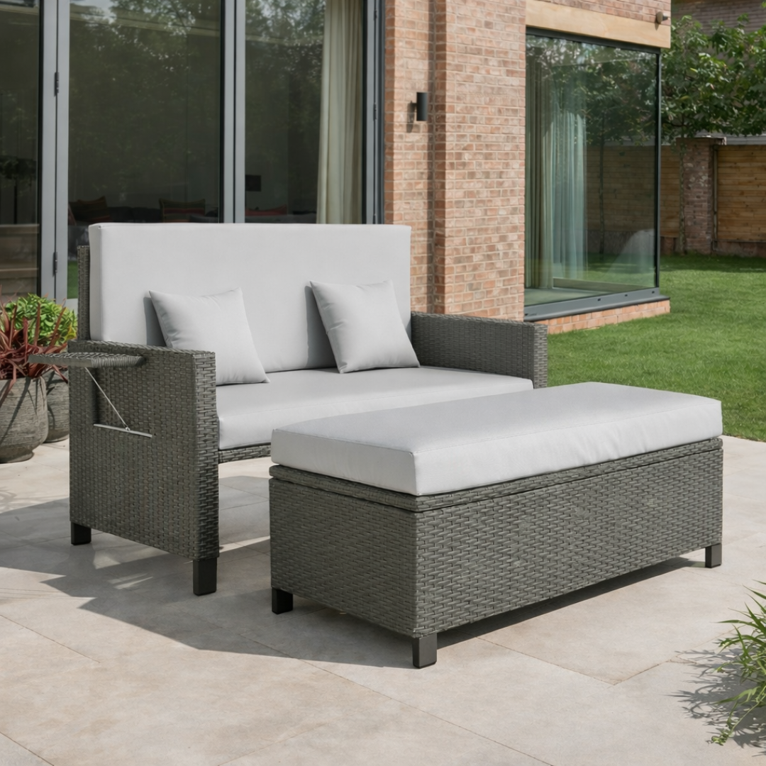 Outdoor patio furniture set with gray cushions on a stone patio.